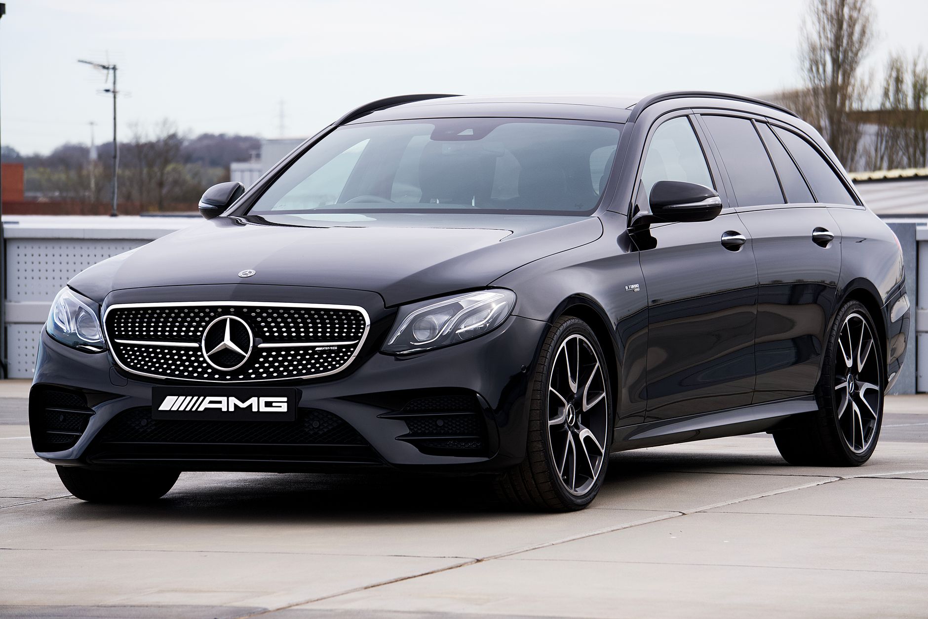 A luxurious black Mercedes-Benz AMG parked outdoors, showcasing its sleek design and elegance.