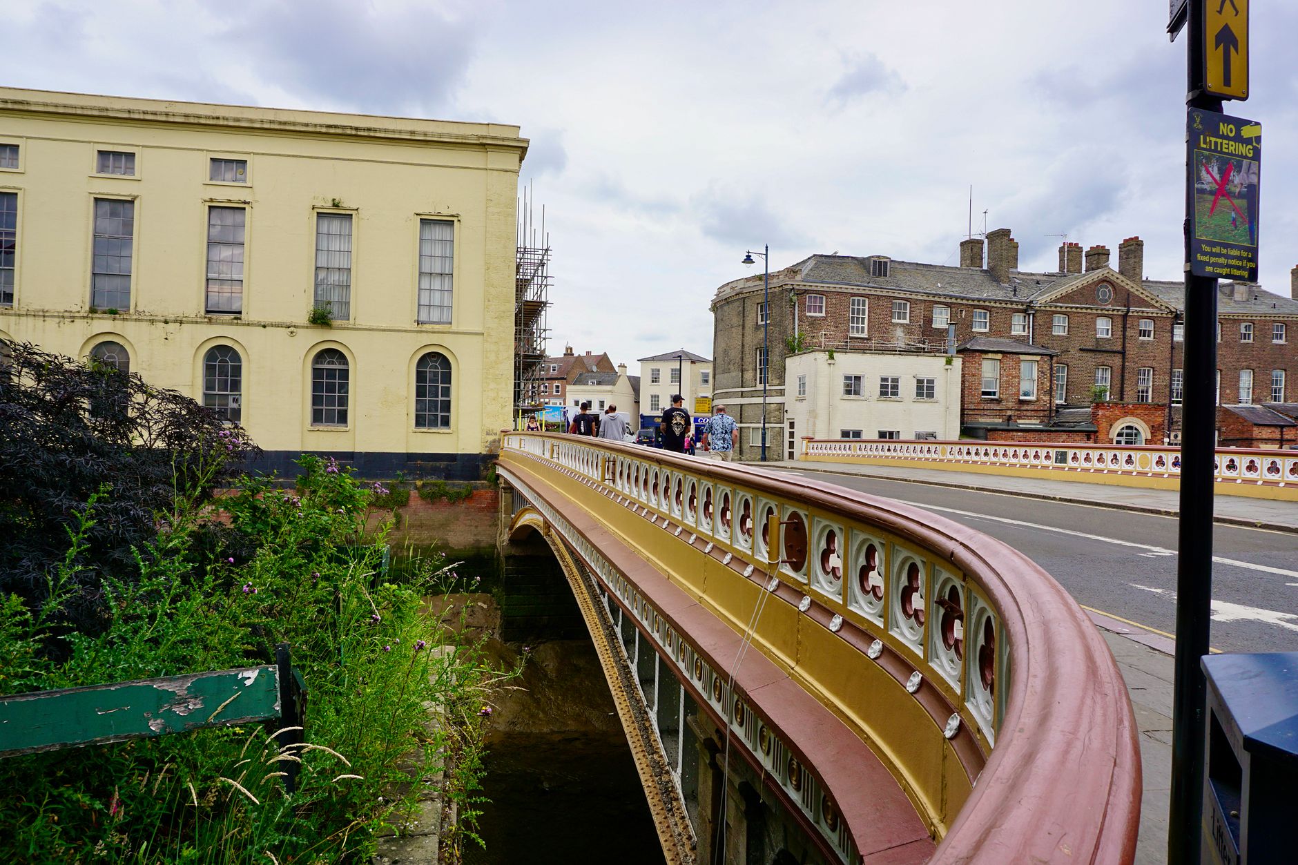 Charming street view of a historic bridge in Boston, England, under a cloudy sky.